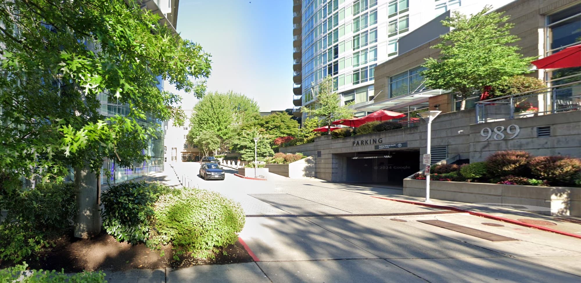 The parking garage entrance under the 989 building, marked with a Parking sign